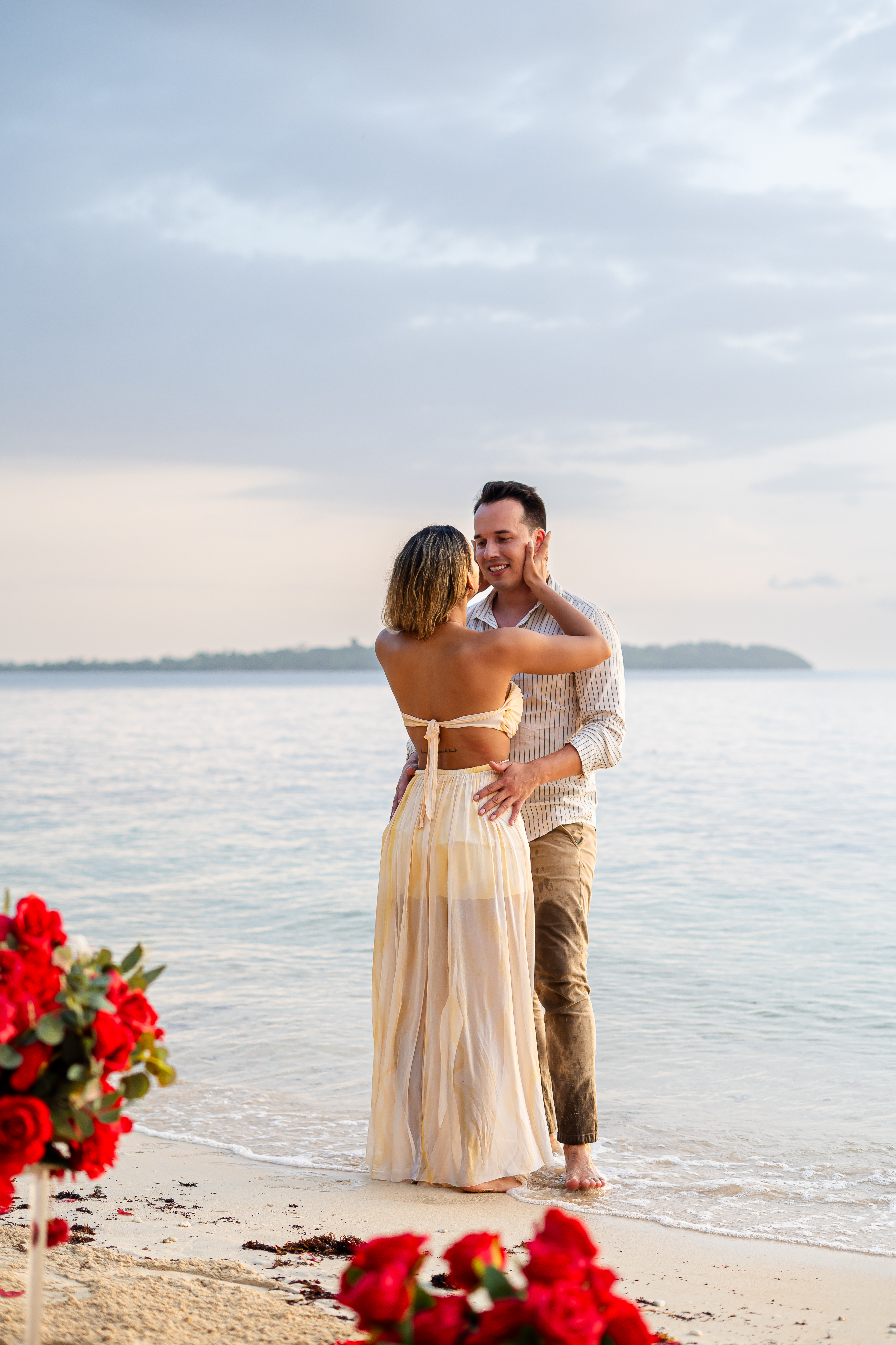 Alex and Suzan standing in shallow water facing the ocean, islands in the distance